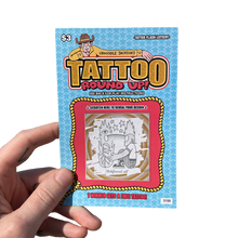 Load image into Gallery viewer, Hand holding a 'Tattoo Round Up!' scratch-off card with a colorful design on a white background.