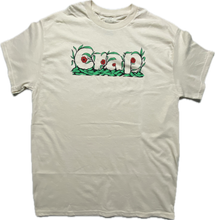 Cargar imagen en el visor de la galería, A cream colored short sleeve tee with the word &quot;Crap&quot; printed on the chest area that is camouflaged in green leaves and red flowers.
