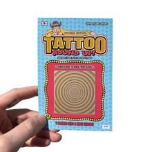 Load image into Gallery viewer, Tattoo round up scratch card held by a hand on a white background
