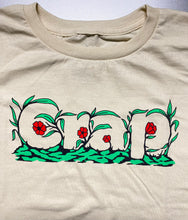 Cargar imagen en el visor de la galería, A close up of a cream colored short sleeve tee with the word &quot;Crap&quot; printed on the chest area that is camouflaged in green leaves and red flowers.
