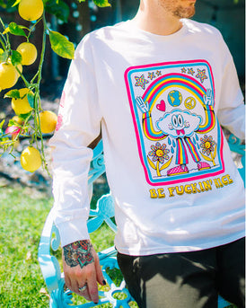 Model in tee.  White long sleeve with the words “Be Fuckin’ Nice” in yellow retro font at the bottom and a cloud character wearing a blue, pink, and yellow striped pantsuit with pink checkered sneakers. The cloud is grinning with 2 tongues sticking out, casting a rainbow between his raised hands with water drops below the armpits watering the 2 yellow and polka dot flowers below his arms. Heart, globe, and peace sign are between the cloud head and the rainbow, 6 polka-dotted stars are above the rainbow.