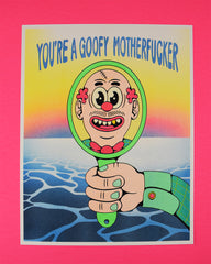 Risograph print of a cartoon hand holding up a mirror with a reflection of a goofy looking fellow who is balding with curly red hair on the sides of his head, cartoonish oval eyes, a scar across his bald head, and one gold tooth showing through a big smile framed by a meek mustache. The top of the print reads "YOU'RE A GOOFY MOTHERFUCKER" in a tall, thick, and rounded font. The background features an gradient ocean and a blue-red-yellow gradient sunset. The print is laying on top of a red background.