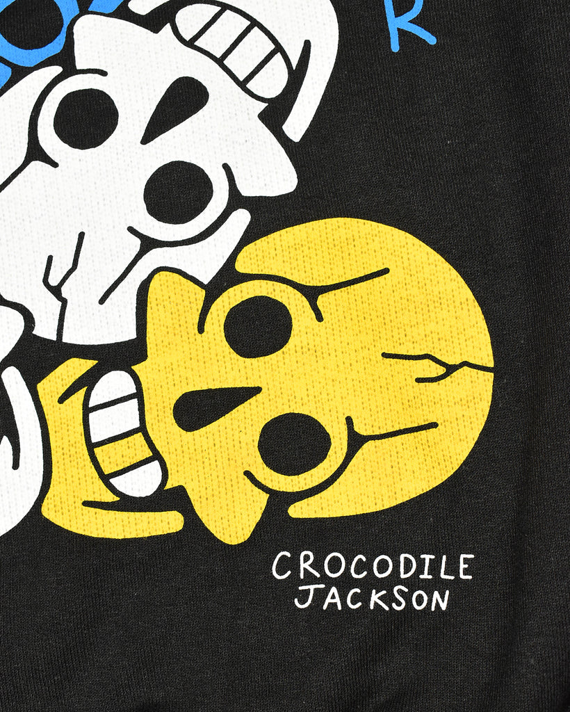 A close up of 2 of the smiling skulls, one is white and one is yellow.  This is highlighting the artist signature - Crocodile Jackson - at the bottom right of the artwork.