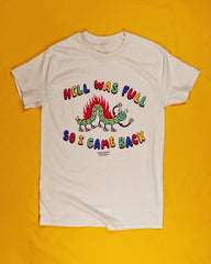 A cream colored short sleeve t-shirt that reads Hell Was Full at the top and So I Came Back at the bottom in alternating red, yellow, green and blue colored letters.  The center is a a smiling cartoon inch worm with 6 legs and tennis shoes for its feet.  The top of the worm has flames shooting up and it has two arms in the air showing off its muscles.