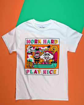 A white short sleeve t-shirt with Work Hard printed at the top of the graphic in the center of the front of the shirt. Play Nice is printed at the bottom. Each letter is a different color of either pink, mint green, hot pink or yellow. The center graphic is a cartoon of a spotted dog with a very long snout, a lava lamp, Cloudia and person with very long legs. All in the same colors as the letters.