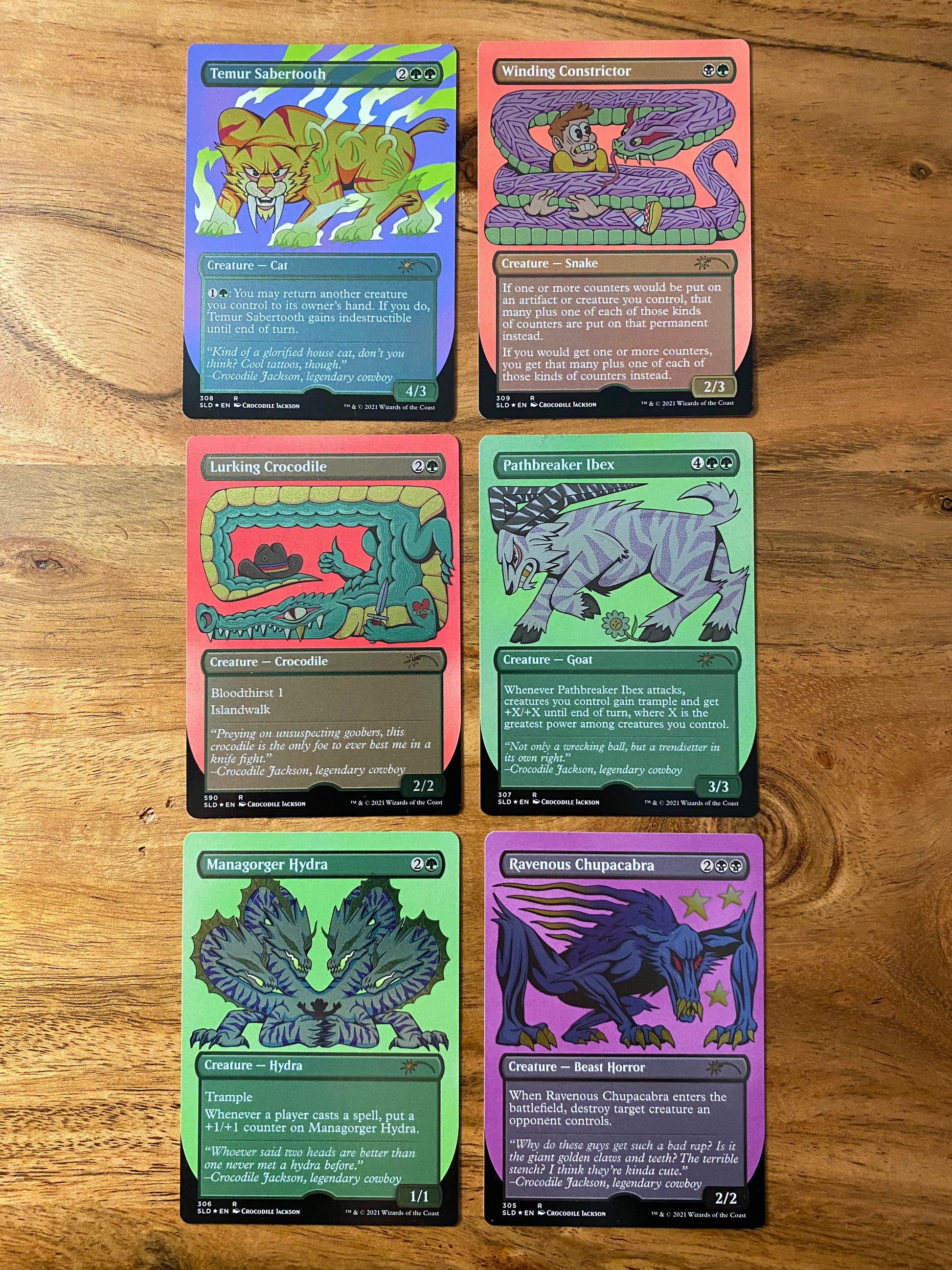 A set of 6 trading cards that shimmer in the light when you move them. Each card has a cartoon animal and are part of the Magic the Gathering Secret Lair game by Hasbro.