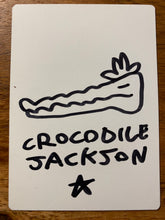 Load image into Gallery viewer, The back of the trading card that is all white with a hand drawn crocodile head with the artist signature below - Crocodile Jackson - in black marker.
